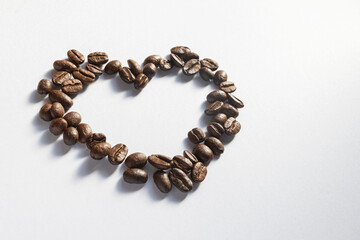 coffee beans in the shape of a heart, side view, isolated on white background, sharp