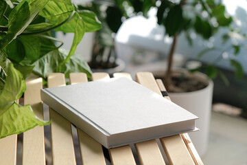 blank book mockup on decorative table with many green plants