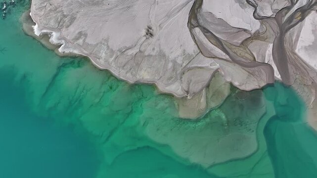 A quadcopter view of Lake Issyk (Almaty Region, Kazakhstan) and the mountain river flowing into it on an autumn morning.