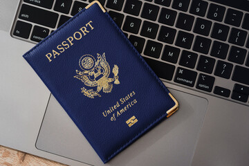 United States passport on laptop keyboard, symbolizing modern travel, digital identity verification, and international documentation