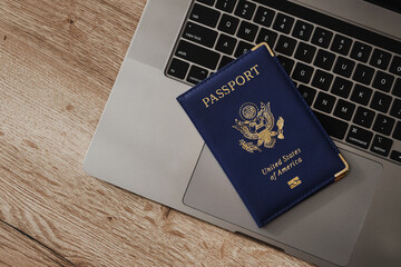 United States passport on laptop keyboard, symbolizing modern travel, digital identity verification, and international documentation