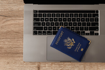 United States passport on laptop keyboard, symbolizing modern travel, digital identity verification, and international documentation
