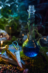 glass bottle filled with a glowing blue liquid stands among green plants and stones. Soft smoke swirls around the bottle, creating an enchanting atmosphere at twilight