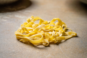 Fresh homemade tagliatelle pasta on kitchen table