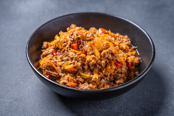 Bolognese sauce with minced meat and vegetables in black bowl