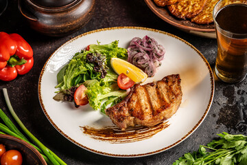 Grilled pork steak with fresh salad and beer