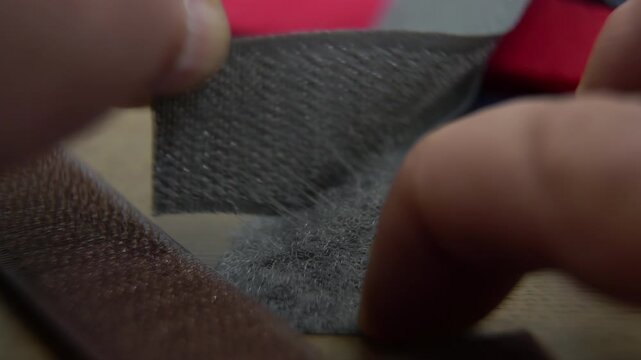 Human hands opening a Velcro strap: The working principle of a Velcro fastener in action