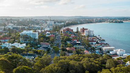 Obraz premium A picturesque view of Manly Beach showcasing its golden shoreline and turquoise waters under the radiant sun.