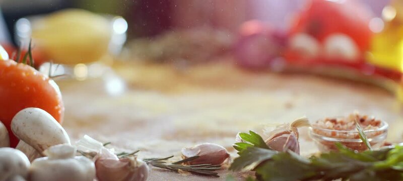 Fine flour falling in slow motion over fresh pizza dough on a wooden board, surrounded by delicious ingredients like tomatoes, mushrooms, garlic, and herbs for an authentic italian recipe