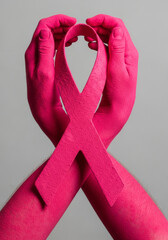 Hands hold pink ribbon. Hopeful and awareness symbol. Breast cancer support, early detection, healthcare. World Breast Cancer Day