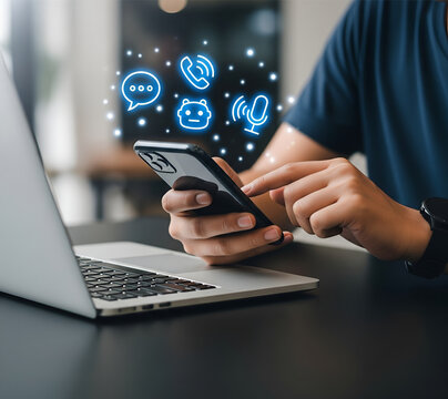 Person using a smartphone with glowing social media and communication icons hovering above the screen in a modern office setting