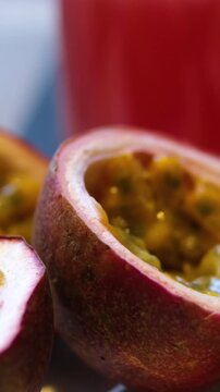 Ripe passion fruits with passion fruit seeds and passionfruit leaves slowly move in the frame on a gray stone table. Nice exotic fruit background for your projects. Macro video shooting. 4k