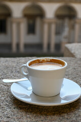 Drinking of italian coffee cappuccino served in museum and castle cafe in Milan, Italy