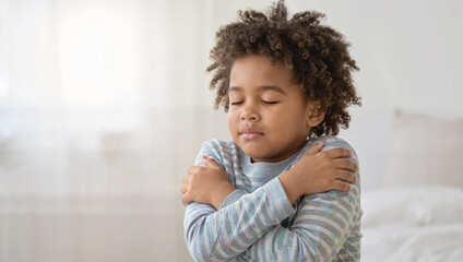 Little boy hugging himself with self-love