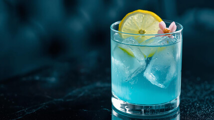 A refreshingly elegant cocktail, the light blue hue of the drink is complemented by a vibrant lemon slice and a delicate flower in the background