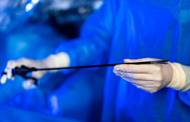 Robotic-assisted surgery with medical team. Medical staff in blue uniforms conduct robotic-assisted surgical procedure in operating room.