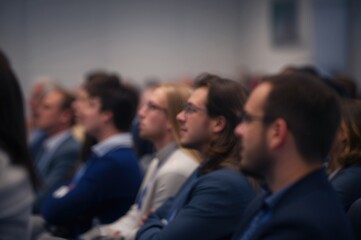 Obraz premium Engaged Audience Listening to Conference Speakers with Blurred Background in Professional Venue Focused on Educational Presentations and Networking