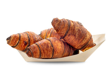 Chocolate croissants arranged on tray made of wood sheets isolated