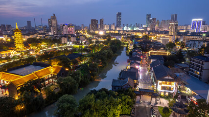 Night view of ancient city with modern buildings and river flowing through