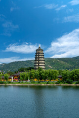 Ancient multi-story pagoda by the lake under a clear blue sky