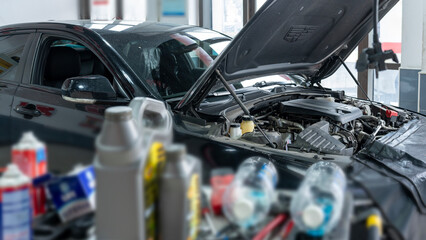 Fototapeta premium Car engine being inspected with various automotive fluids around