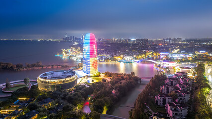 Night view of a modern city with a colorful tower by the water