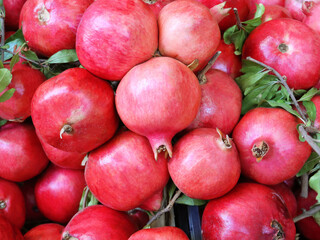 Ripe pomegranate fruits on the counter at the farmer's market. Sale of fruits in the market. Close-up. Healthy food.