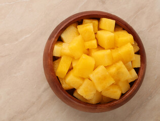 a wooden bowl with pineapple pieces