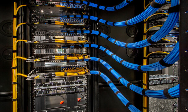 Network Server Rack with Blue Cables in Data Center - Powered by Adobe
