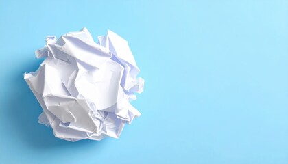Obraz premium Crumpled paper ball on a blue background representing a mistake or creative block