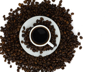 Cup of black coffee surrounded by roasted coffee beans on a white background. Top view of a fresh espresso concept.