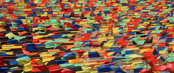 Decorative pennant flags on strings forming a continuous texture of blue, orange, blue, and yellow colors