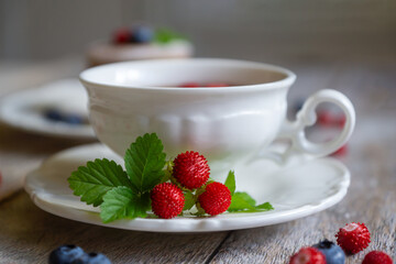 Delicate pancakes with fruits and berries on a wooden table.