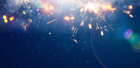Bright sparks light up a dark sky during a festive celebration at snowy winter night. Background.