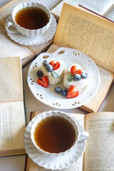 Red currant cake and a cup of aromatic tea in a porcelain cup on the table.