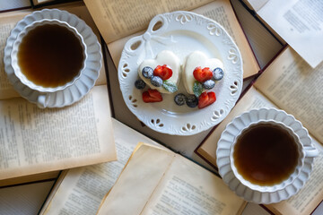 Red currant cake and a cup of aromatic tea in a porcelain cup on the table.