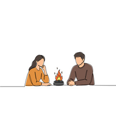 Young couple sitting by a small flame and sharing a conversation  