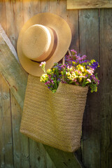 Wild flowers in a beautiful straw bag and a straw hat.