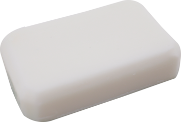 A simple white bar of soap in rounded rectangle shape lying on a white surface PNG cutout transparent background isolated