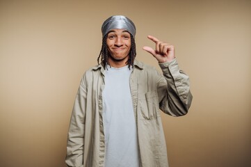 Smiling person making a gesture with their hand, showcasing a small object or idea indoors