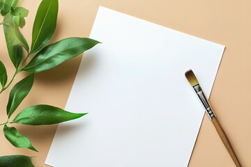 Blank paper sheet with paint brush and green leaves on beige background