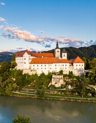 Panoramic view of a historic European castle complex situated on a riverbank
