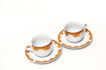 Elegant White and Gold Porcelain Coffee Cups and Saucers on a Clean White Surface