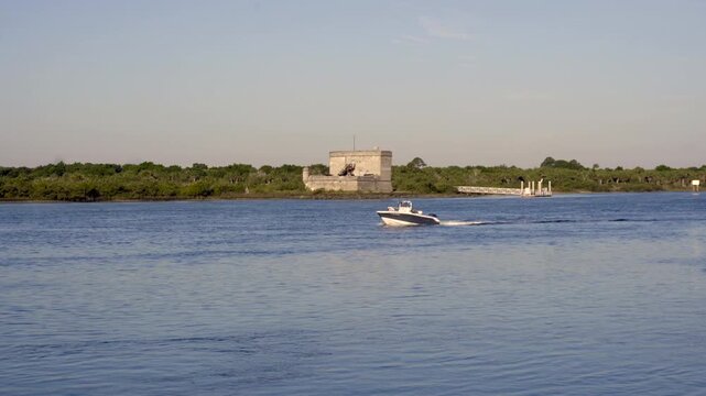 St. Augustine, Florida: Boat on Mantanzas Inlet near Fort Matanzas National Monument. Spanish fort in conjunction with Castillo de San Marcos National Monument. Spanish Cross of Burgundy flag.