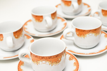 Elegant tea cups and saucers with orange floral design create a charming ambiance