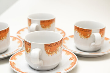 Elegant tea cups with orange patterns on saucers set a charming atmosphere