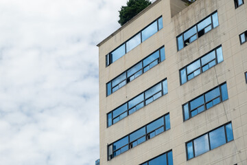 View of old building facade with reflection of blue sky on the windows