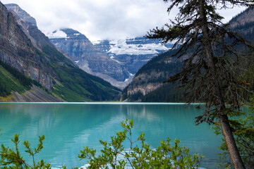 Panoramic view of a Canadian lake with green water surrounded by mountains and glaciers