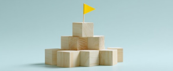 The wooden block pyramid topped with a yellow flag symbolizing achievement and leadership