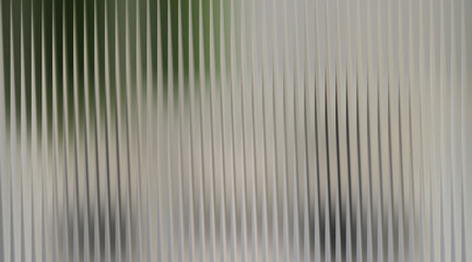 Fototapeta premium Abstract background with vertical ribbed texture and blurred green and gray elements